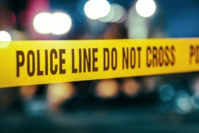 Yellow Tape Showing Text Police Line Do Not Cross Restricting a Crime Scene Area At Night. Close Up Aesthetic Shot with Bokeh Effect and Flickering Lights. Criminal on the Loose Strikes Again