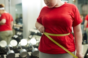 Portrait,Of,Unrecognizable,Obese,Woman,Standing,Against,Mirror,In,Gym