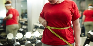 Portrait,Of,Unrecognizable,Obese,Woman,Standing,Against,Mirror,In,Gym
