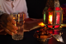 A young man prays and drinks water and eats dates. Evening meal during the Holy Muslim month of Ramadan